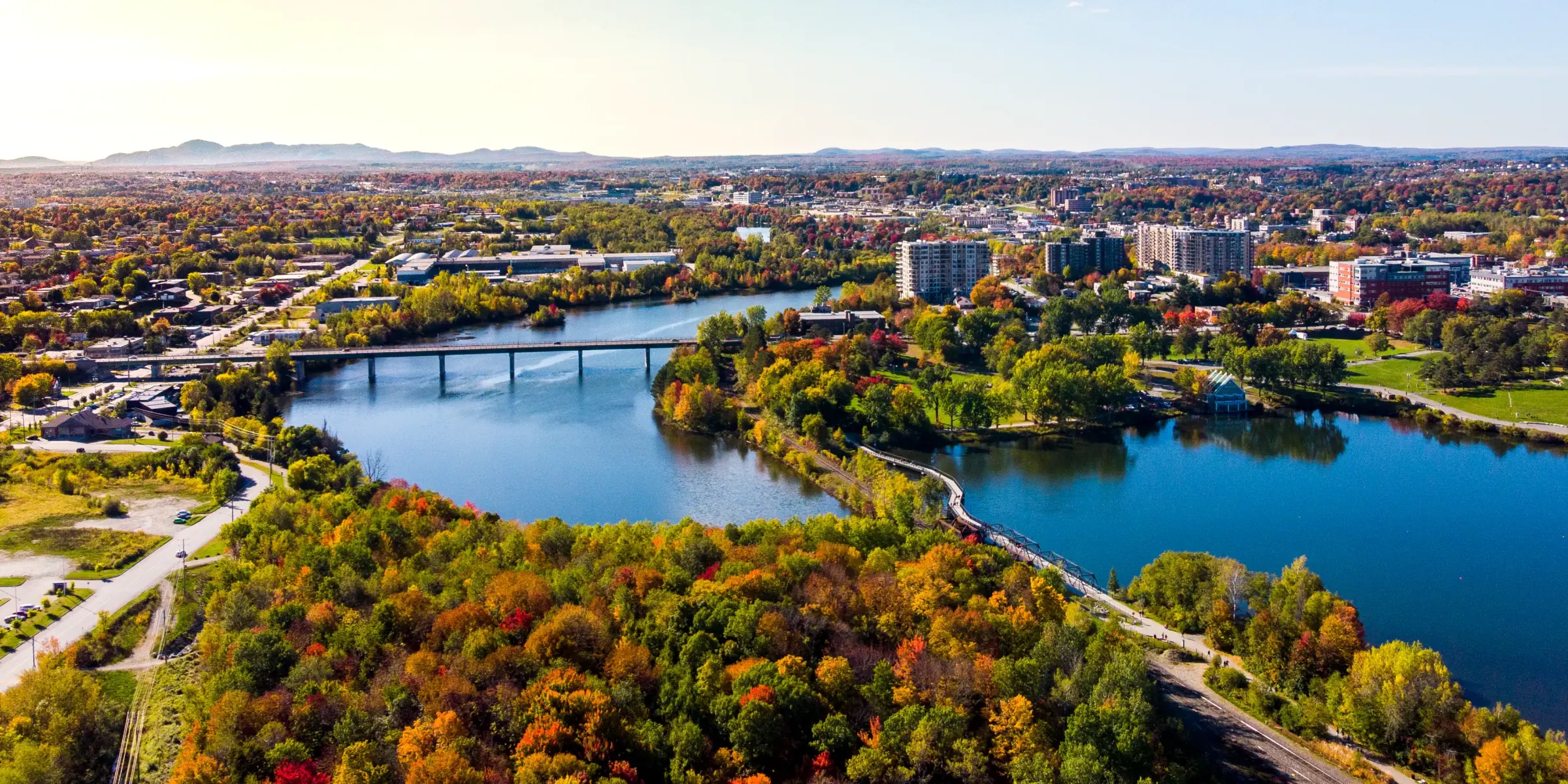 Vue aérienne d’une ville québécoise et de sa rivière en automne